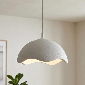 Minimalist grey textured pendant light with a wavy edge design hanging in a bright, modern room.