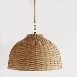 A large woven rattan pendant light, dome-shaped with a natural brass chain, against a plain white background.