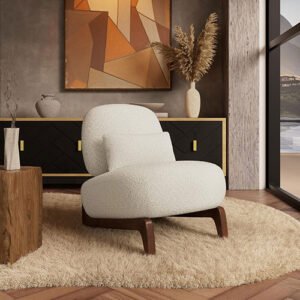 Elegant cream boucle armchair with dark wood legs on a round jute rug, featuring a fluted wood sideboard and abstract art in the background