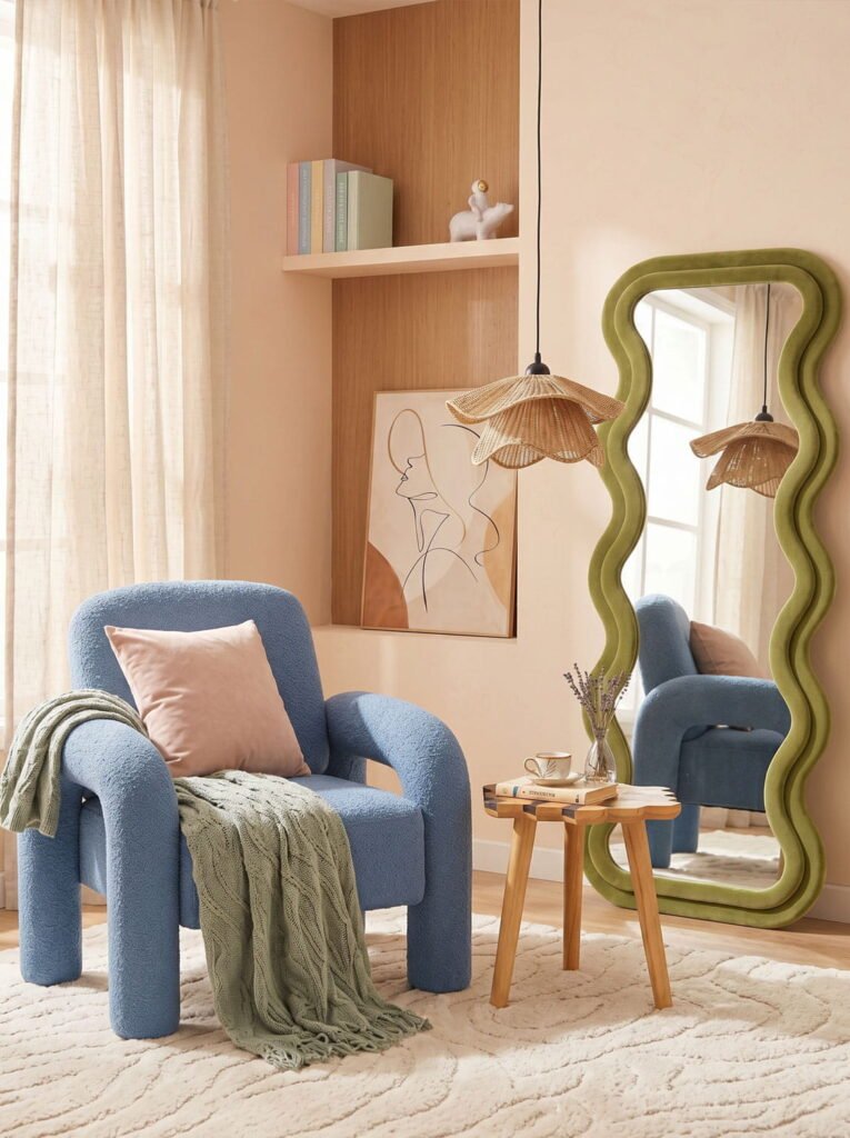 Sage green wavy floor mirror next to a modern blue armchair and a wooden side table in a cozy, well-lit living room.