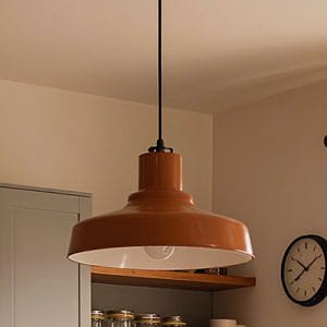 Industrial-style terracotta pendant light with a wide metal shade hanging in a modern kitchen.
