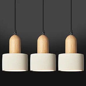 Set of three modern pendant lights featuring light wood tops and white cylindrical ceramic shades.
