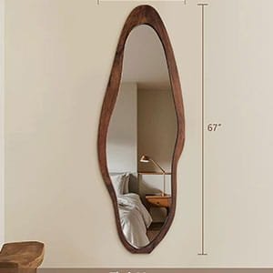 Vertical wall-mounted mirror with an irregular, organic-shaped dark wood frame