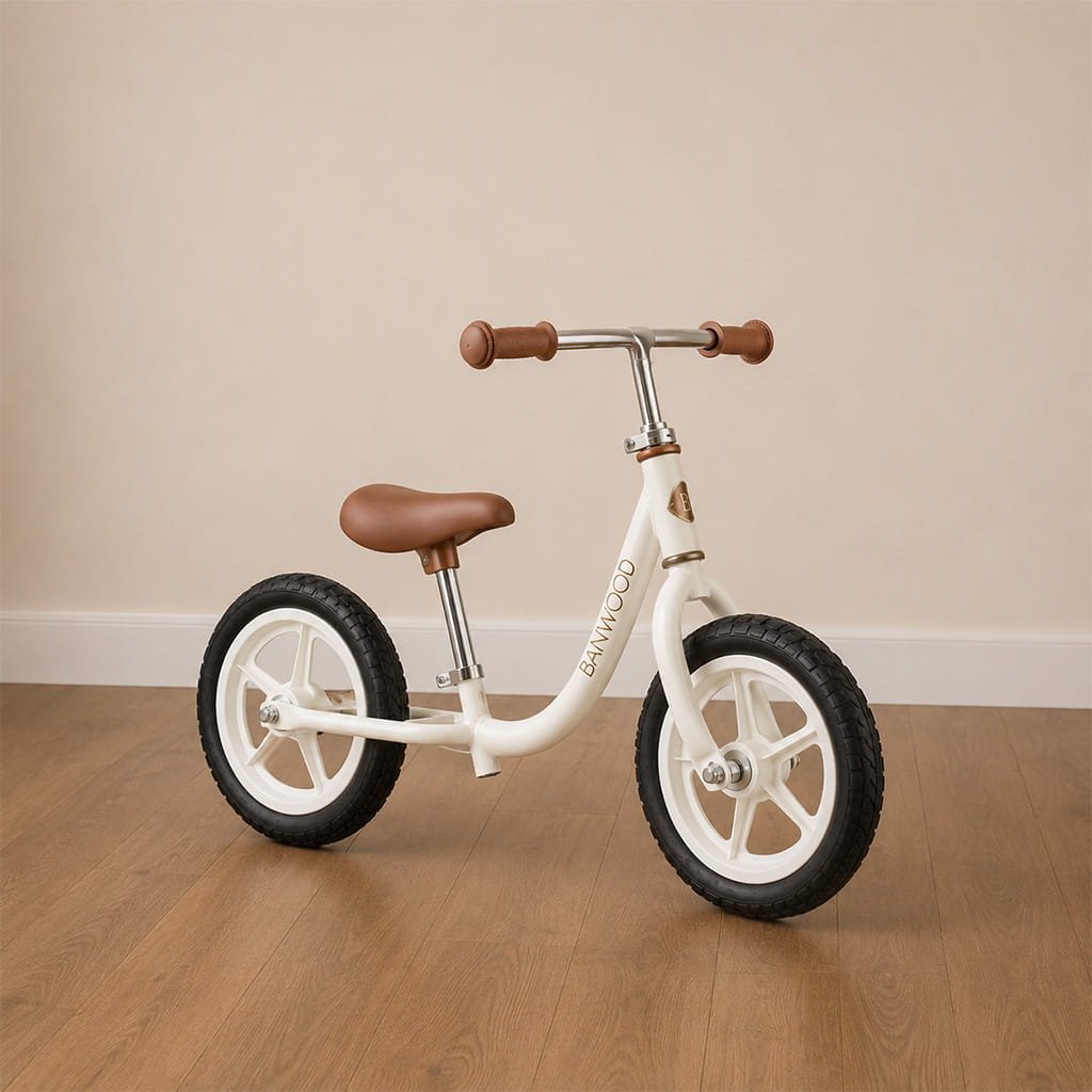 Montessori balance bike for toddlers in white with brown leather details on a neutral floor